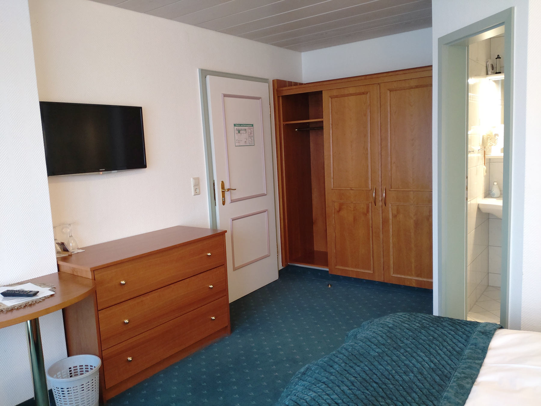 Ost-Doppelzimmer mit Holzdielen, Doppelbett und Blick auf grüne Wiese