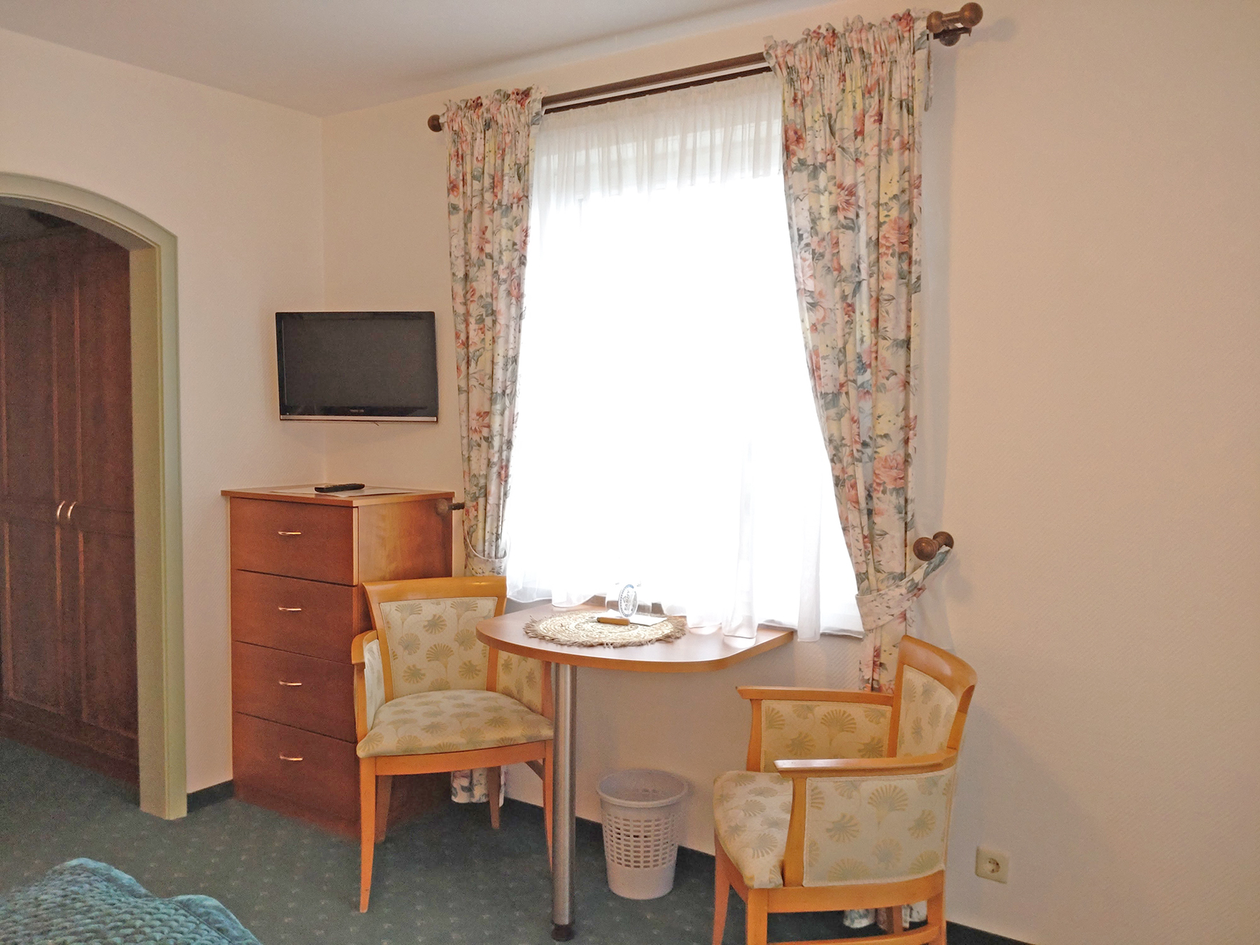 Süd-Doppelzimmer mit Doppelbett, Holzdielen, Nachttischlampen und großem Fenster mit Blick ins Grüne