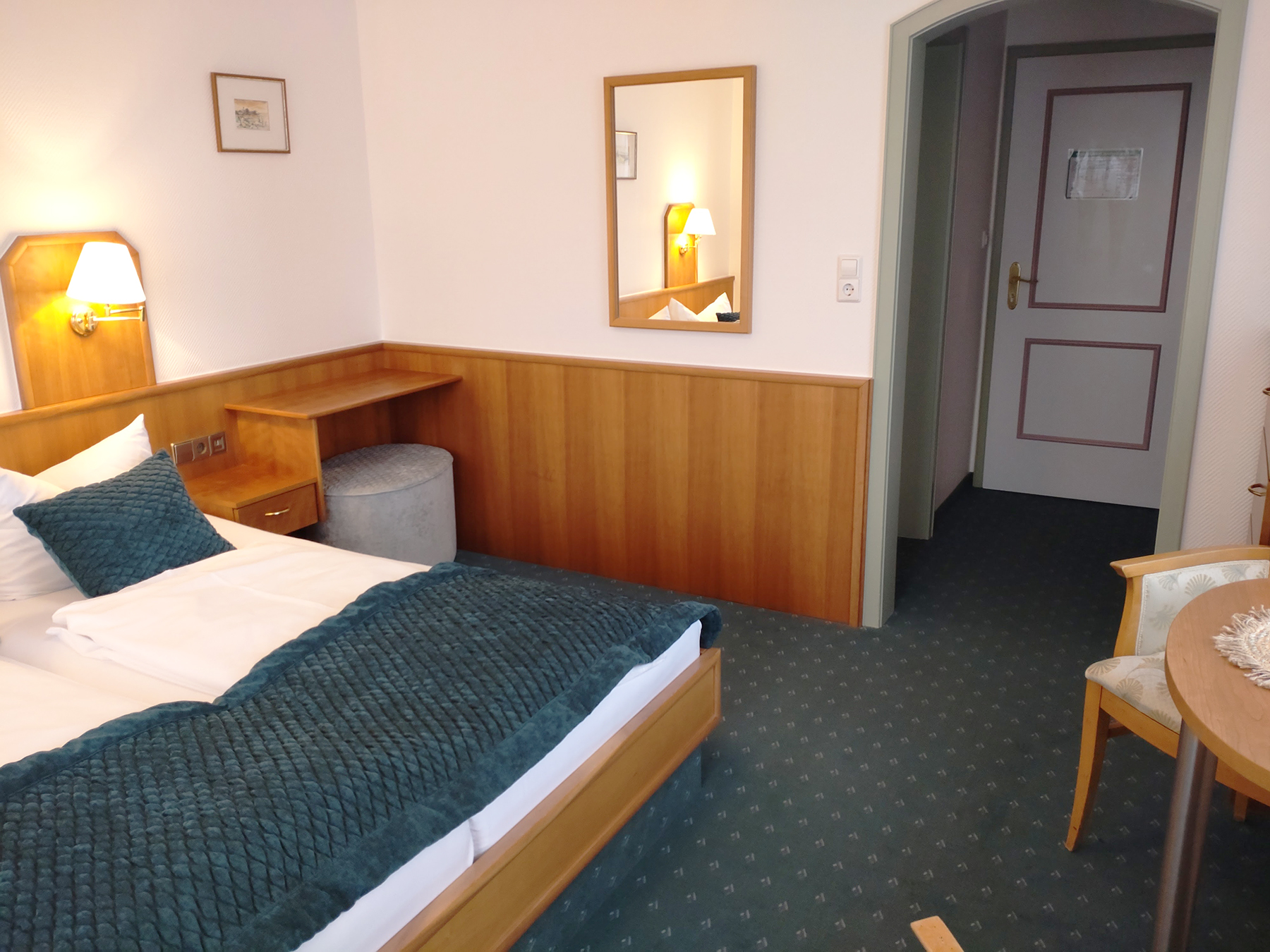 Süd-Doppelzimmer mit Doppelbett, Holzdielen, Nachttischen und Panorama-Fenstern