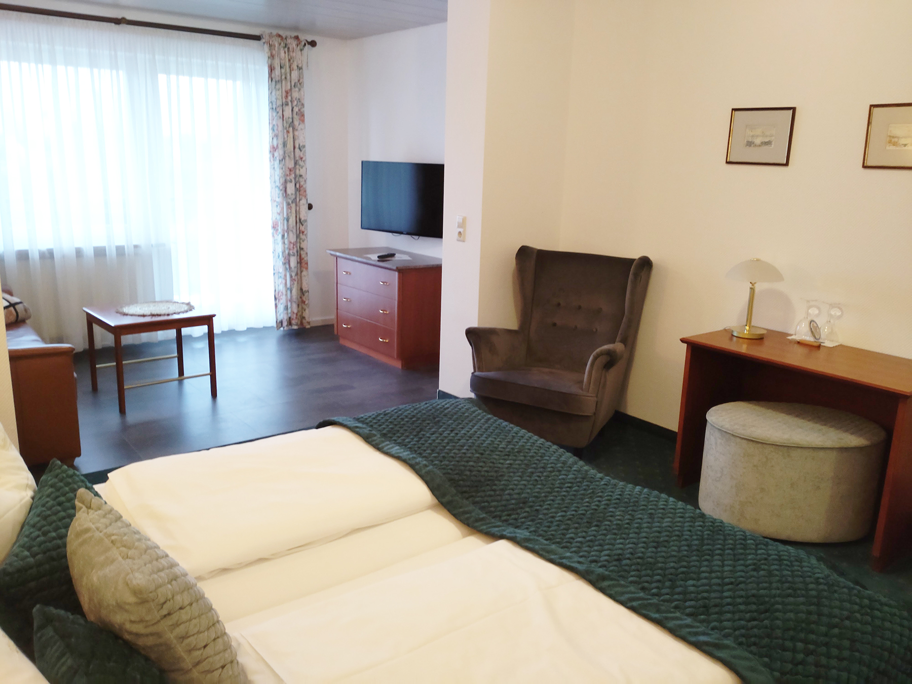 Junior Suite mit Doppelbett, gemütlicher Sitzecke, Holzboden und großem Fenster